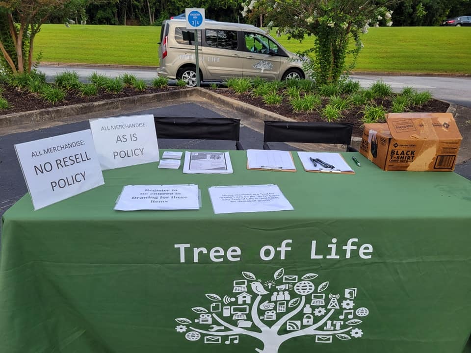 Tree of Life community outreach event with branded table and van